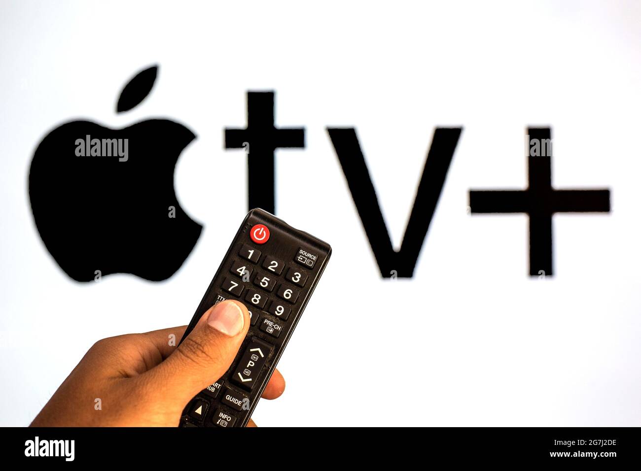 España. 13th de julio de 2021. En esta imagen se muestra un primer plano de  una mano que sostiene un mando a distancia del televisor delante del  logotipo de Apple TV. (Foto