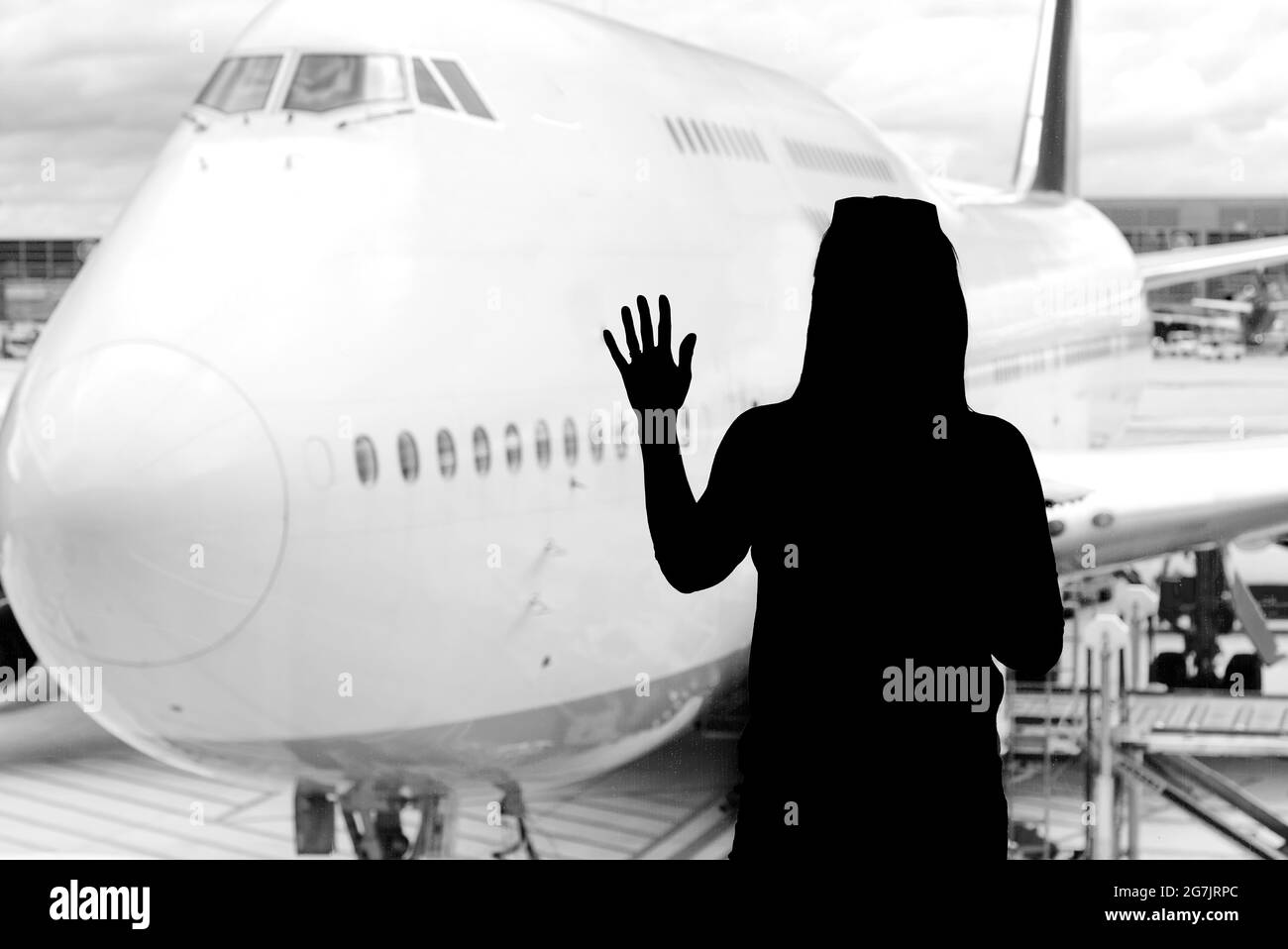 Silueta de mujer negra mirando a los aviones en el pasillo del aeropuerto- concepto de vuelo perdido o cancelado. Foto de stock