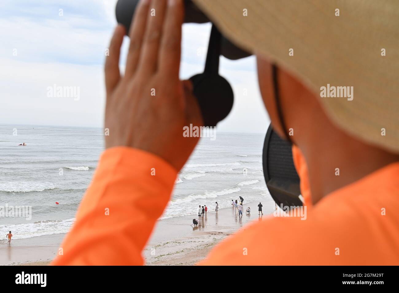 QINGDAO, CHINA - 15 DE JULIO de 2021 - Un miembro de la tripulación de rescate observa la situación de seguridad en el mar dentro de la torre de observación de la playa de baño Balandai en Qingdao, provincia de Shandong en China oriental, 15 de julio de 2021. (Foto de Liu Qiang / Costfoto/Sipa USA) Foto de stock