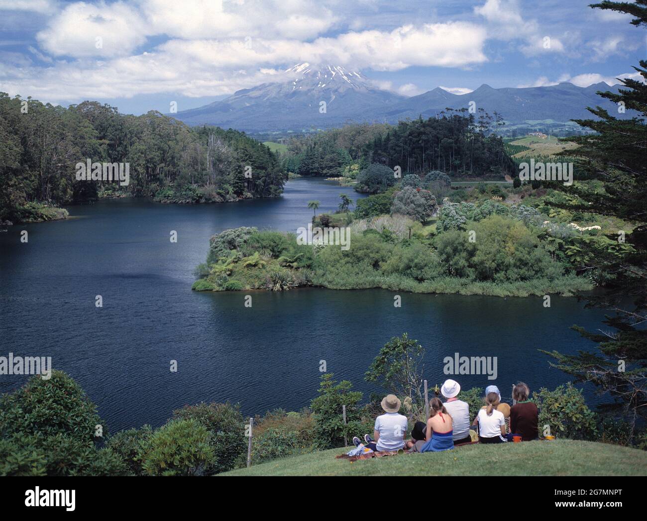 Nueva Zelanda. Isla Norte. Parque Nacional Egmont. Grupo de personas que ven el Lago Mangamahoe y el Monte Egmont. Foto de stock
