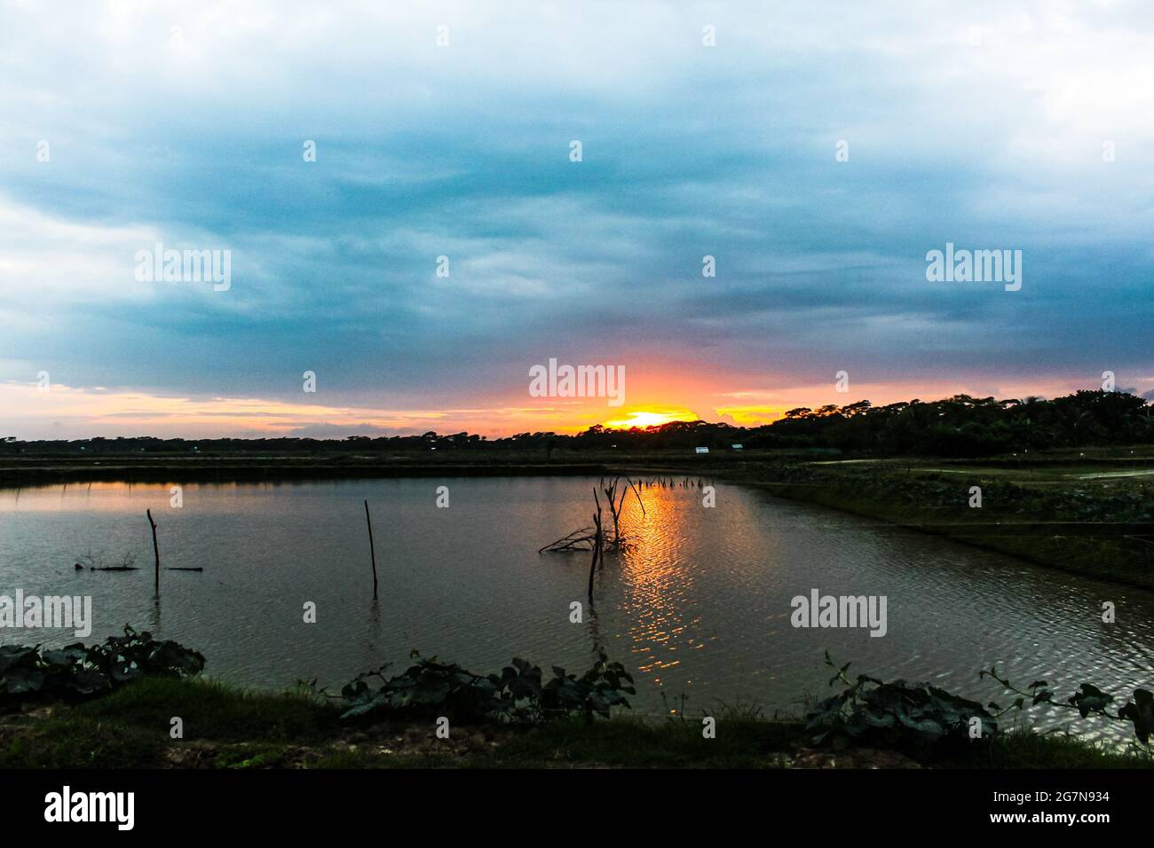 Brillo dorado después, hermosa vista del paisaje de la puesta de sol con lago tranquilo, atardecer asiático colorido, mejor vista de la puesta de sol nunca. Foto de stock