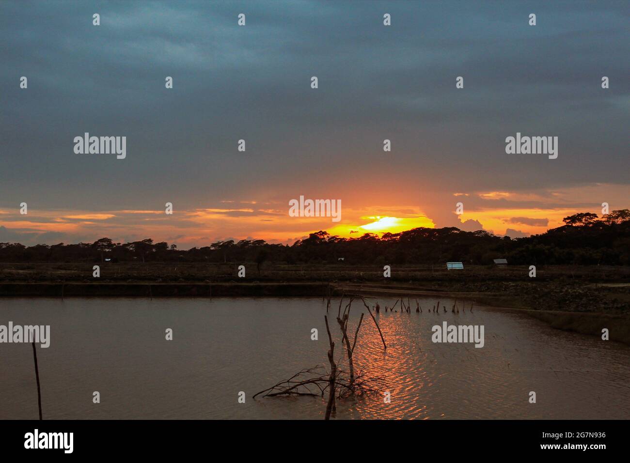 Brillo dorado después, hermosa vista del paisaje de la puesta de sol con lago tranquilo, atardecer asiático colorido, mejor vista de la puesta de sol nunca. Foto de stock