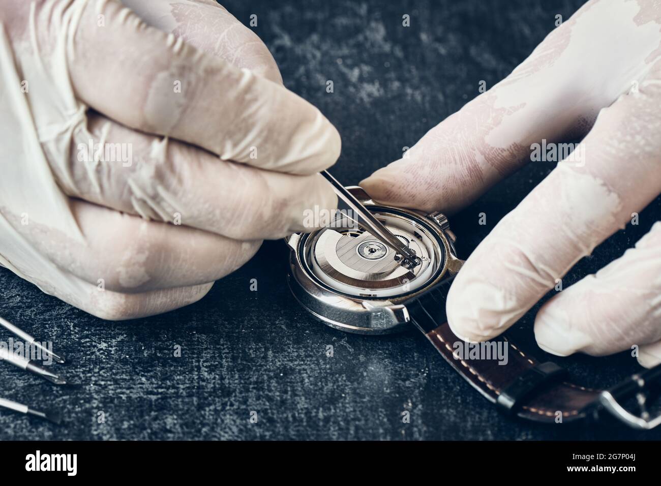 Detalles del relojero Trabaja con pinzas en guantes de vinilo, macro,  reparación de relojes de pulsera Fotografía de stock - Alamy