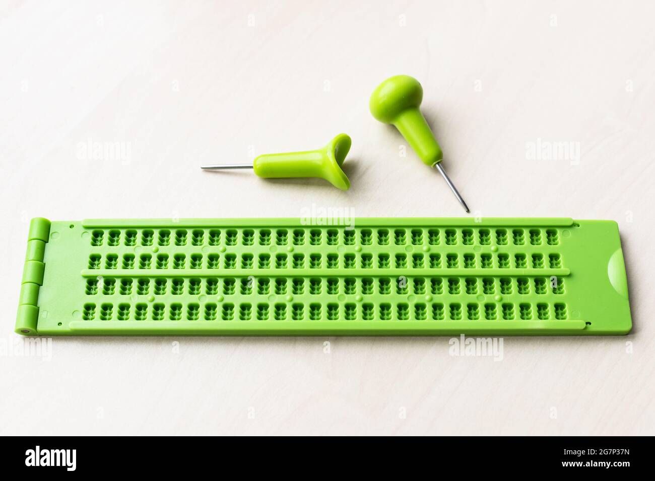 pizarra de plástico braille y lápiz sobre mesa marrón Fotografía de stock -  Alamy
