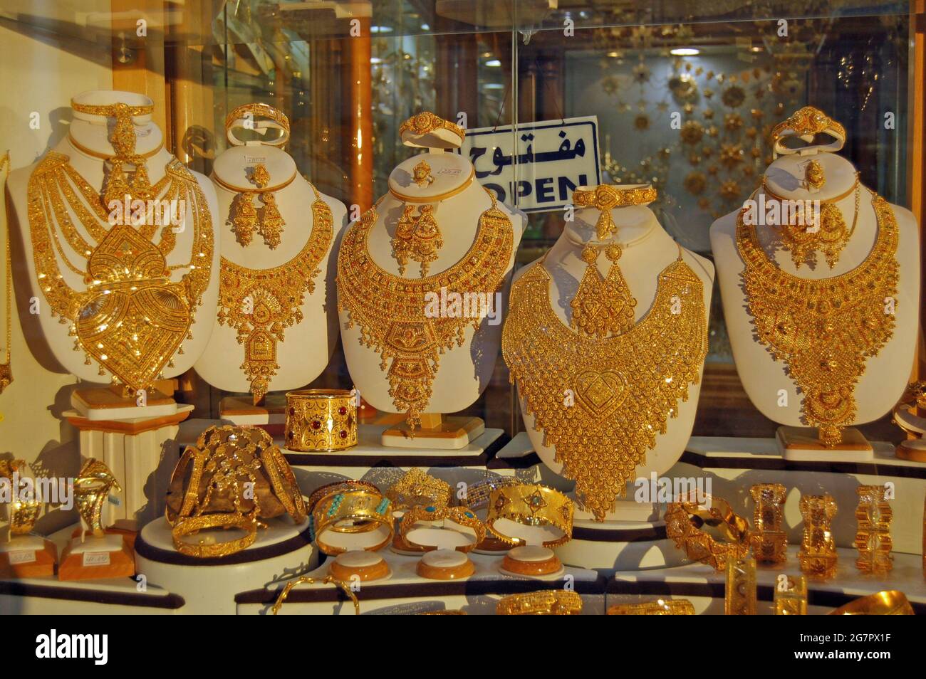 Misrata, Libia - 1 de abril de 2006: Collares de oro, pulseras, anillos y pendientes brillando en el sol de la noche en la ventana de una joyería en Foto de stock