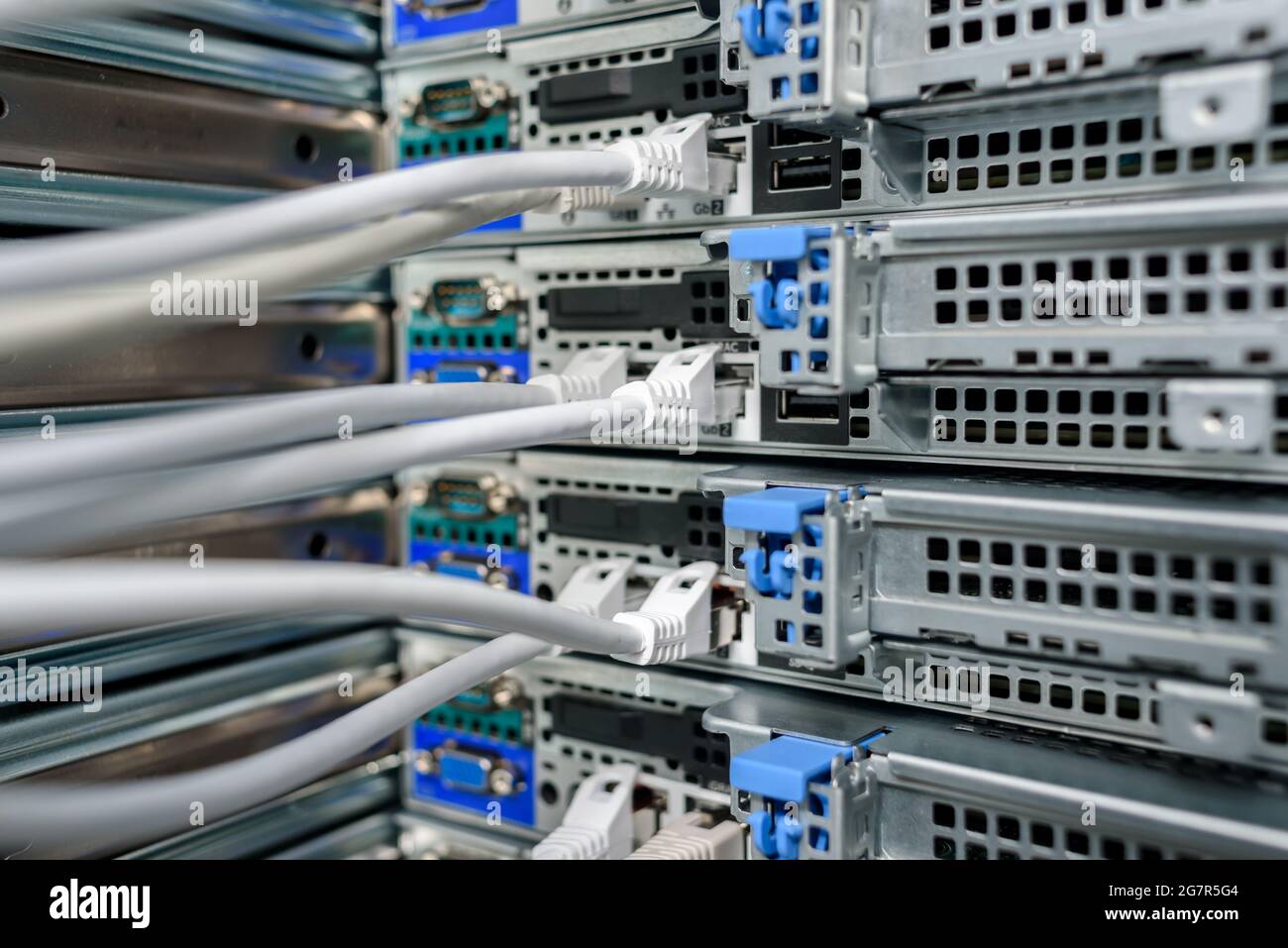 Servidores, switches o routers en funcionamiento en el centro de datos con una gran cantidad de lámparas y cables LED Foto de stock