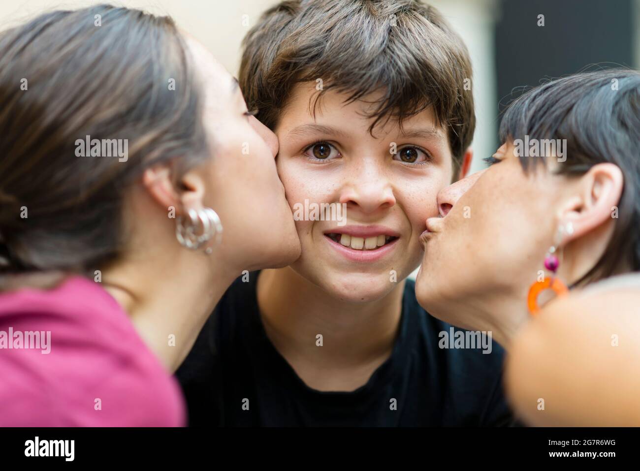 Disgustado niño besando por mamá y hermana Foto de stock