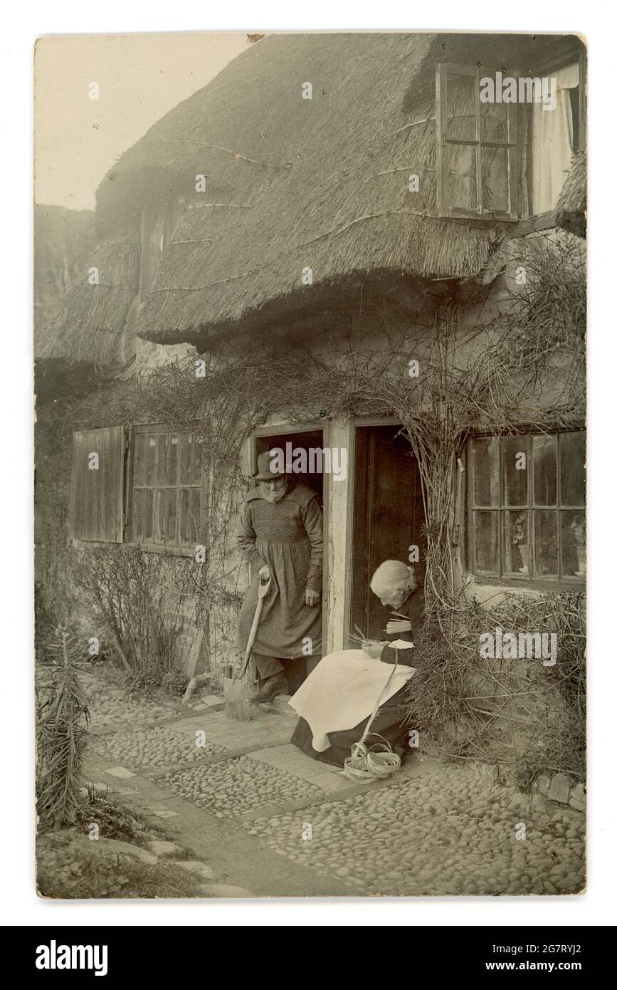 Original a principios de 1900 's real postal de saludos fotográficos de casas rurales y habitantes, cabaña de paja, artesanía rural, el hombre lleva un esmudo, posiblemente un pastor, alrededor de 1905, Reino Unido Foto de stock