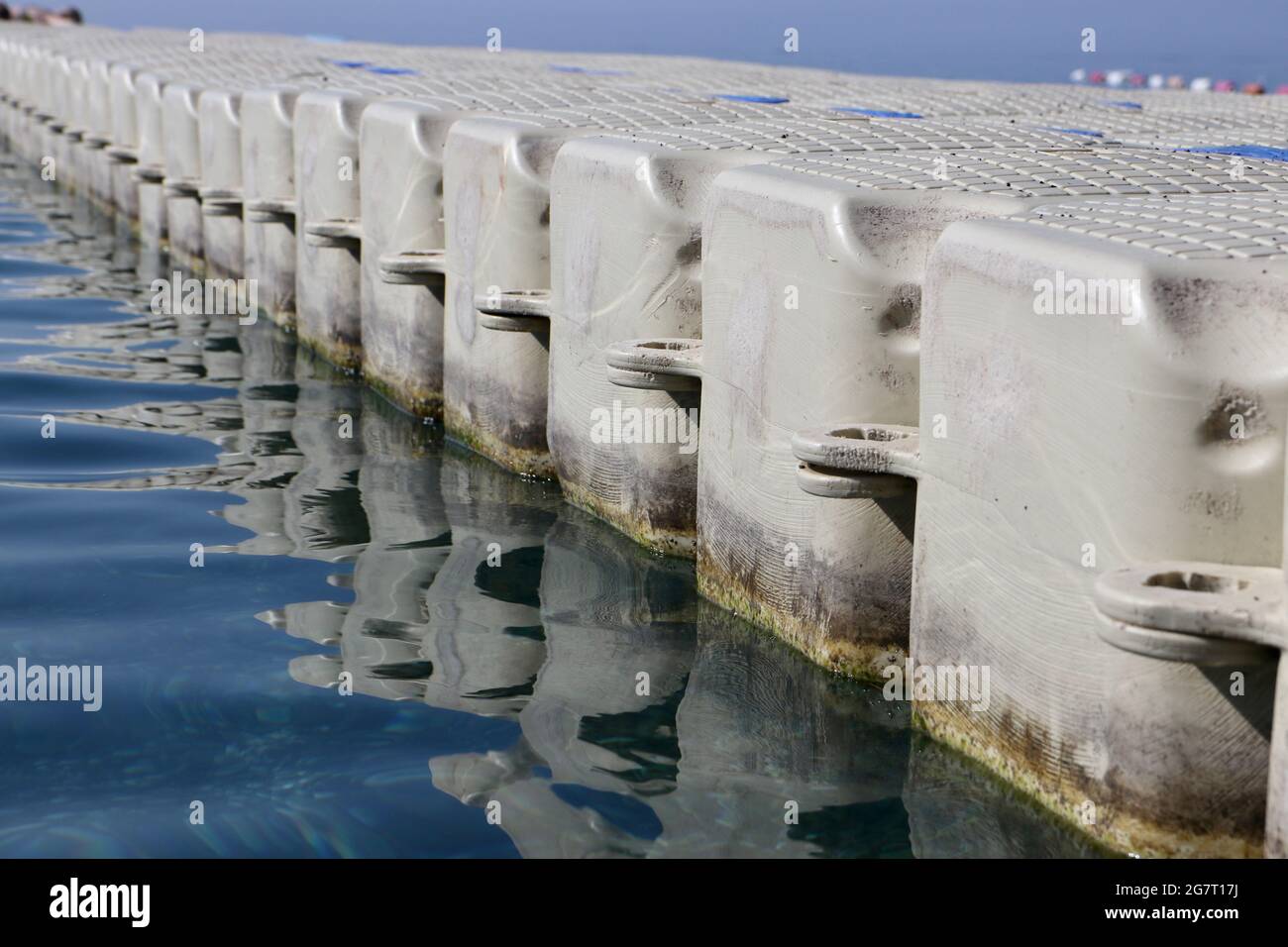 Paseo de plástico con pontón flotando en las pequeñas vías del mar Foto de stock