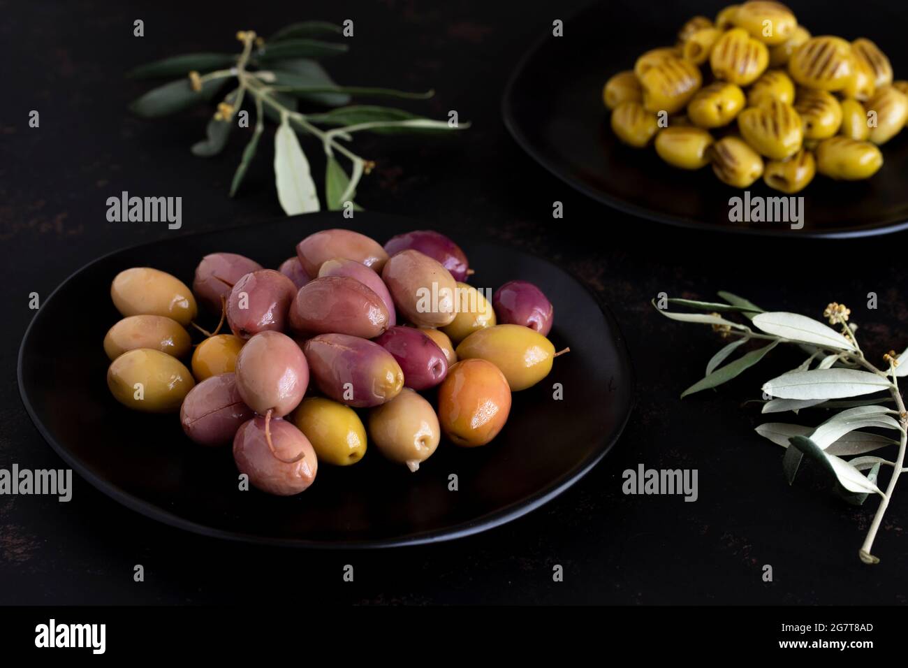 Aceitunas marinadas mixtas (verde y morado) sobre fondo oscuro