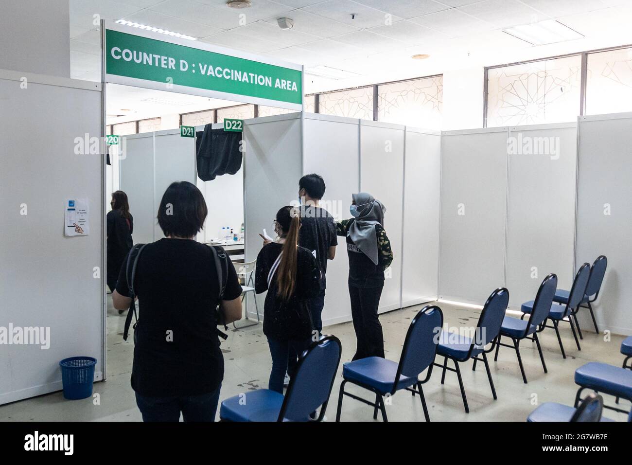 KUALA LUMPUR, MALASIA, 16 de julio de 2021: Personas que esperan su turno para entrar en la zona de vacunación de Covid-19 en el Programa Nacional de Vacunación de Malasia en Foto de stock