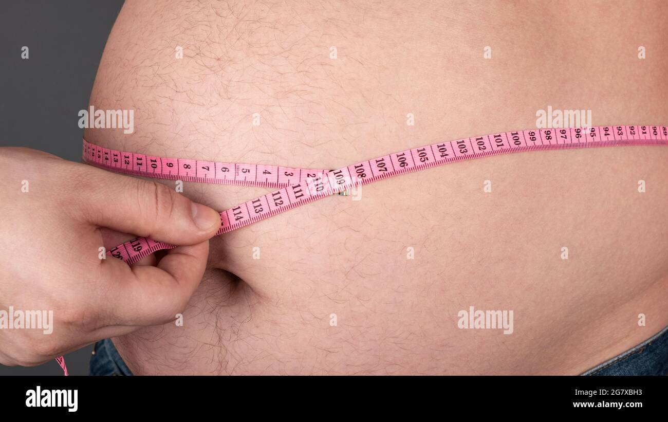 concepto de la obesidad, mide un vientre gordo grande con un centímetro. Foto de stock