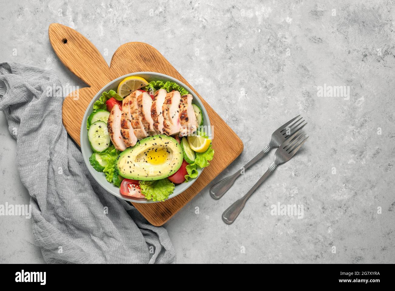 Pollo a la parrilla con ensalada de verduras frescas sobre un fondo de hormigón gris. Concepto de alimentos saludables. La dieta del keto. Vista superior, diseño plano Foto de stock