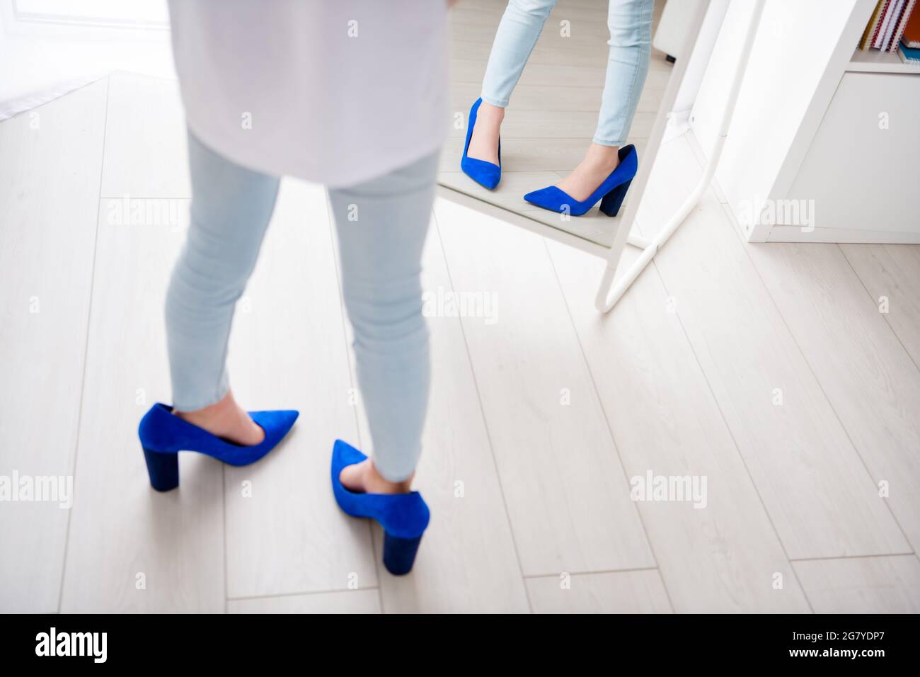 Foto recortada de niña pequeña que lleva zapatos de la madre tacones de  gran tamaño imitar crecimiento dama espejo en el interior Fotografía de  stock - Alamy