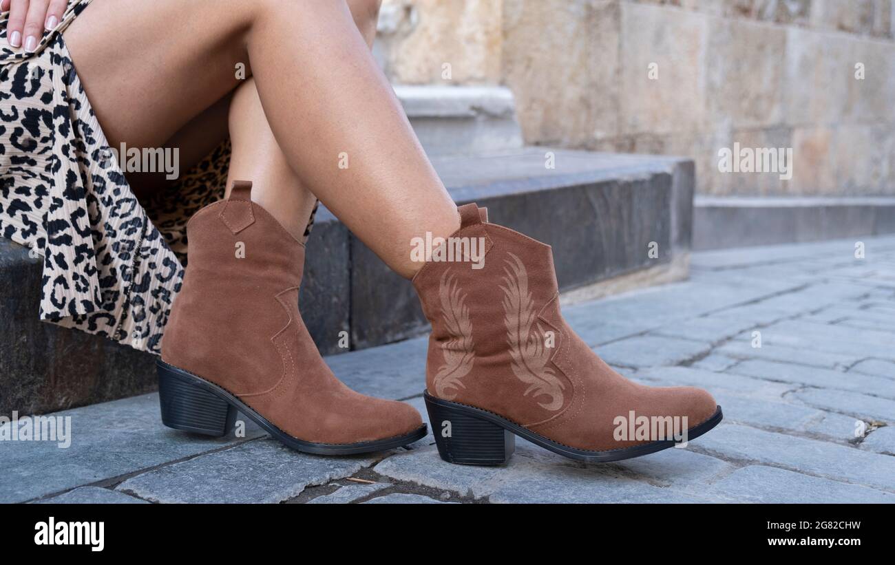 Mujer joven que usa falda larga.Cowboy estilo moda y elegancia Look.Young  mujer en botas de vaquero marrón en la vieja calle de piedra Fotografía de  stock - Alamy