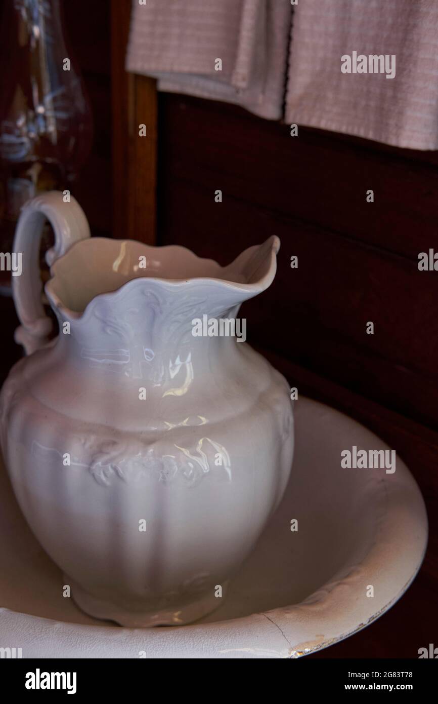 Un lavamanos de porcelana blanca y antigua y una jarra descansa sobre un  soporte de madera. Las toallas de mano blancas cuelgan en el fondo  Fotografía de stock - Alamy