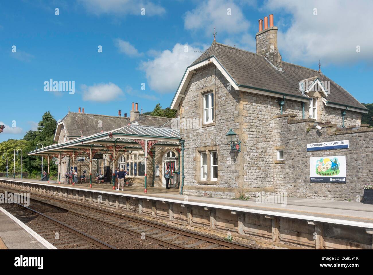 Gente esperando en la estación de tren en Grange over Sands, Cumbria, Inglaterra, Reino Unido Foto de stock