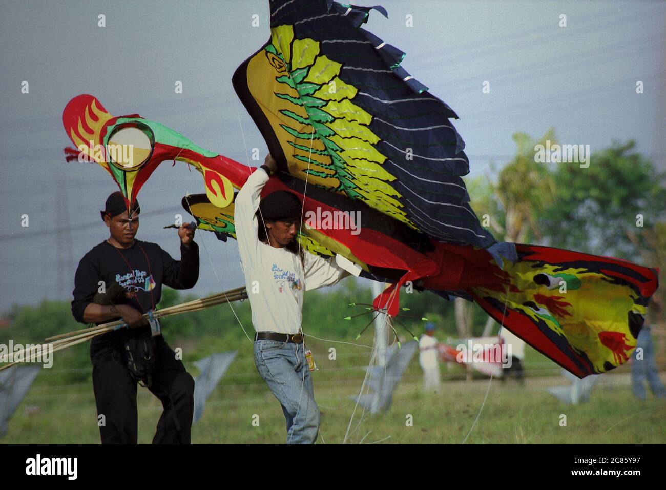 Un participante que transportaba una cometa gigante que fue diseñada para representar a un Garuda durante el Festival Internacional de Kite de Yakarta 2004 que tuvo lugar el 9-11 de julio en Carnival Beach en Ancol Dreamland, North Jakarta, Yakarta, Indonesia. Foto de stock