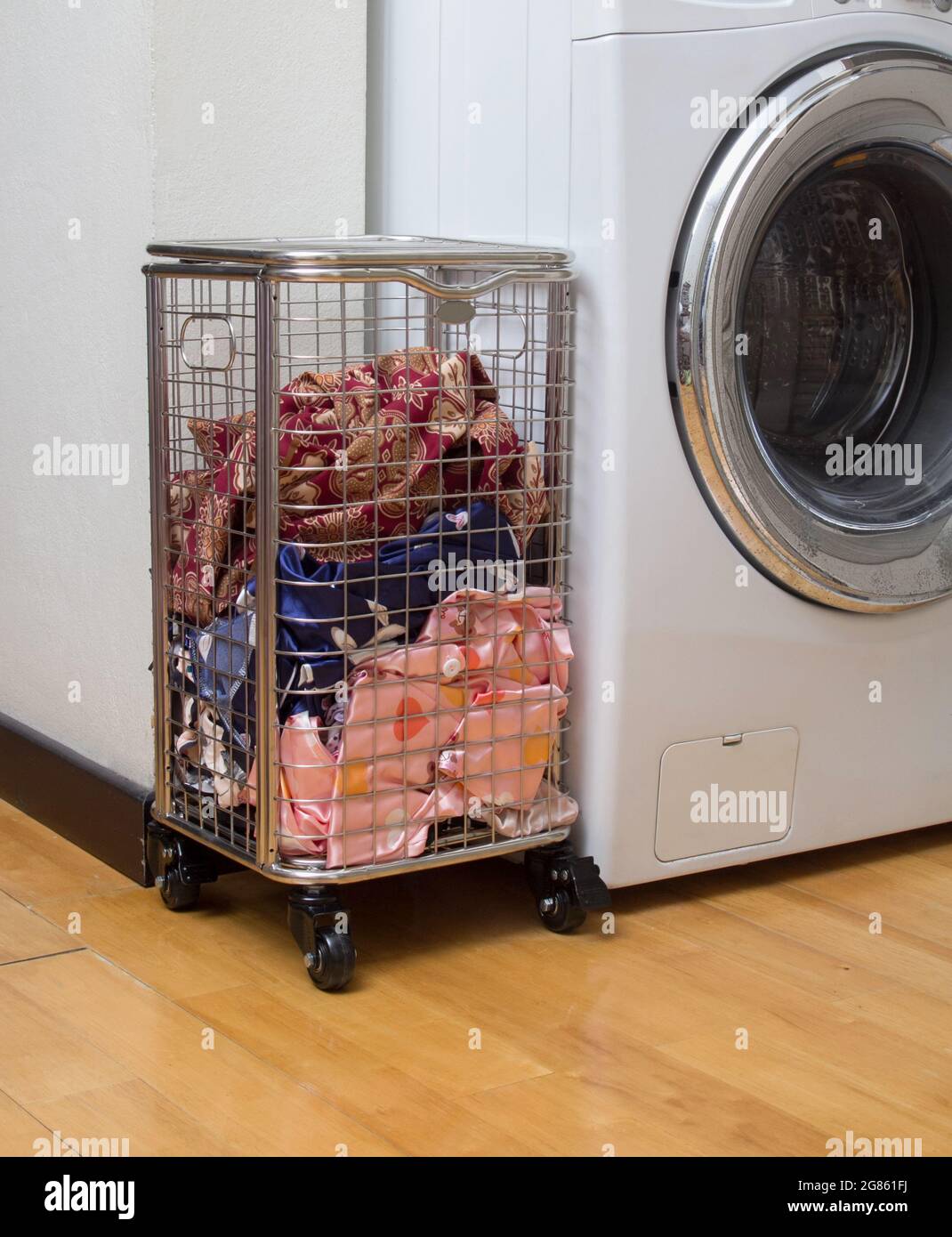 Lavandería cesta de acero inoxidable con ruedas con paños sucios cerca de  la lavadora en la sala de lavandería Fotografía de stock - Alamy