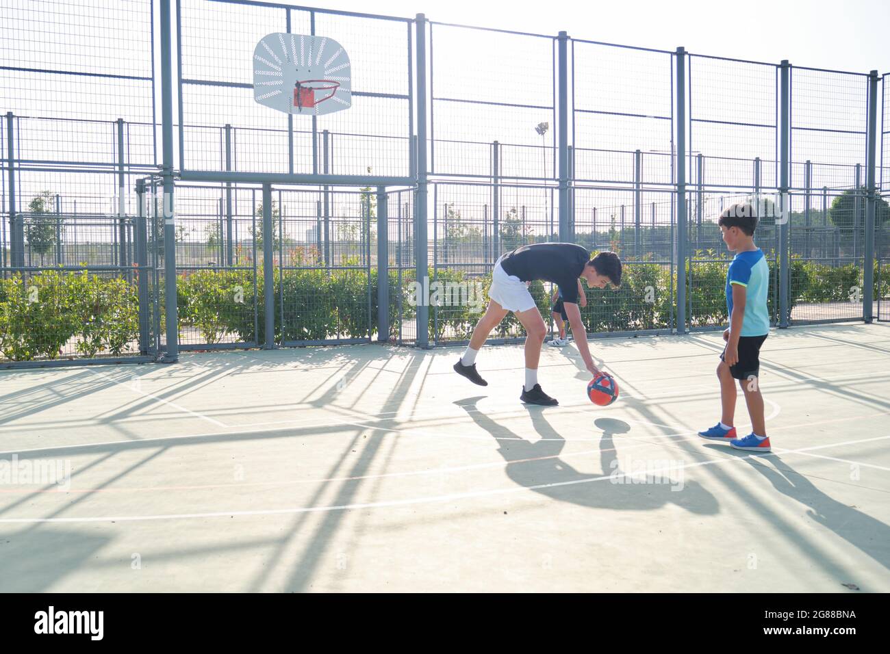 Sofá jugando al fútbol con dos estudiantes. Uno de ellos tiene una prótesis de pierna y está pateando una pena. Foto de stock