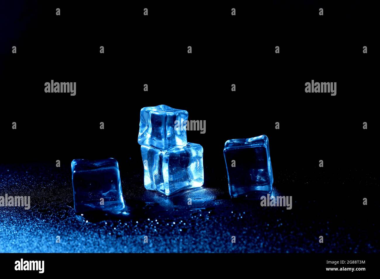 5 Cubo de hielo falso azul o artificial mojado sobre fondo negro Foto de stock