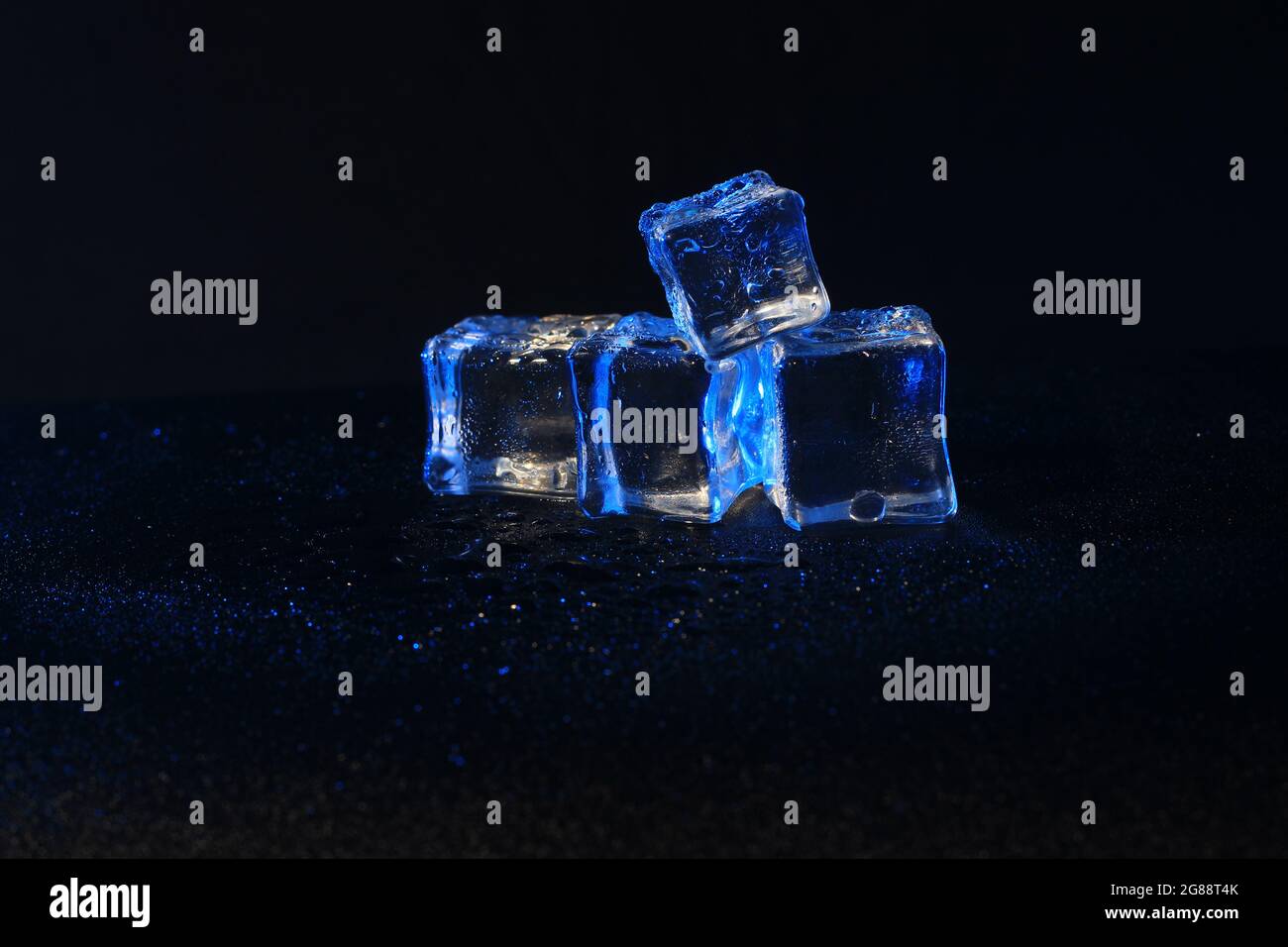 5 Cubo de hielo falso azul o artificial mojado sobre fondo negro Foto de stock