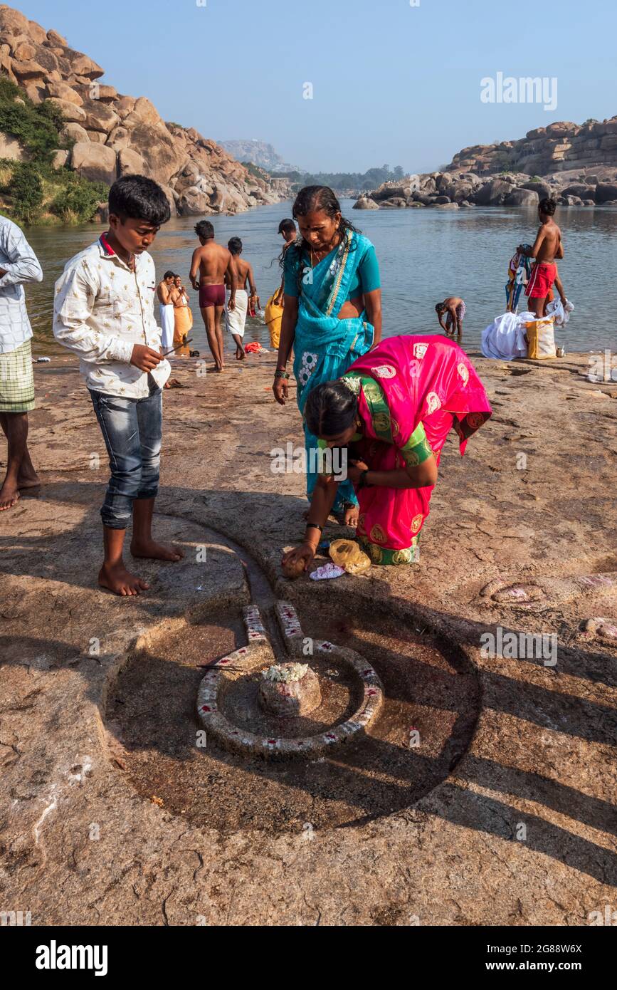 Hampi, Karnataka, India - 10 de enero de 2020 : personas bañándose y preparándose en las orillas del río Tungabhadra en Hampi Town. Foto de stock