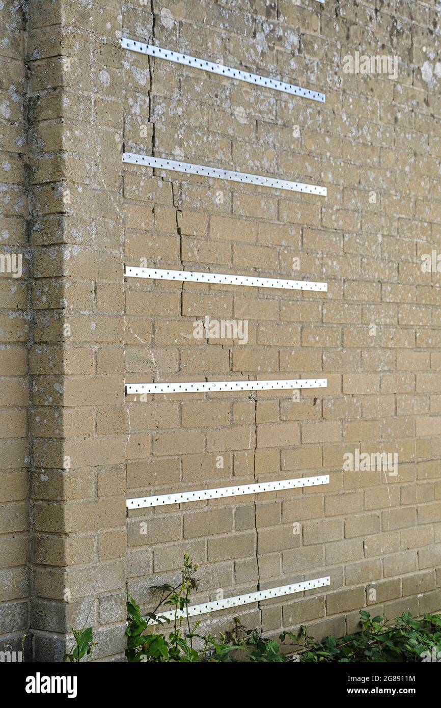 Bandas de fijación de acero a través de la pared para estabilizar la grieta en la pared Foto de stock
