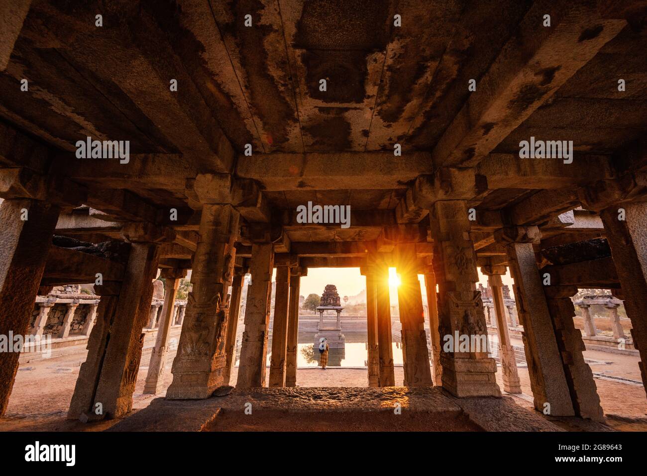 Hampi, Karnataka, India - 14 de enero de 2020 : Vista del amanecer en Pushkarni, tanque de Sri Krishna en ruinas. Lado sur de la piscina con santuario. Cantos rodados y mou Foto de stock