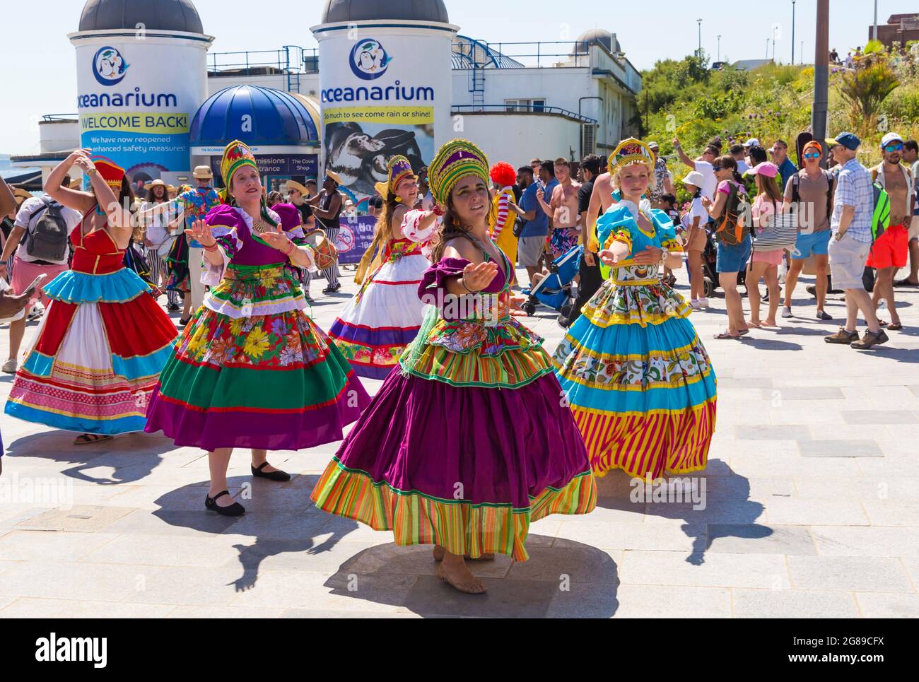 Bournemouth, Dorset, Reino Unido. 18th de julio de 2021. Afon Sistema con sus bailarines de remolinos con faldas coloridas juegan a Maracatu, el primo más terrorero de Samba del noreste de Brazilas actúan como parte de la Serie de Verano Arts by the Sea en un día soleado y lleno de gente en la costa. Crédito: Carolyn Jenkins/Alamy Live News Foto de stock