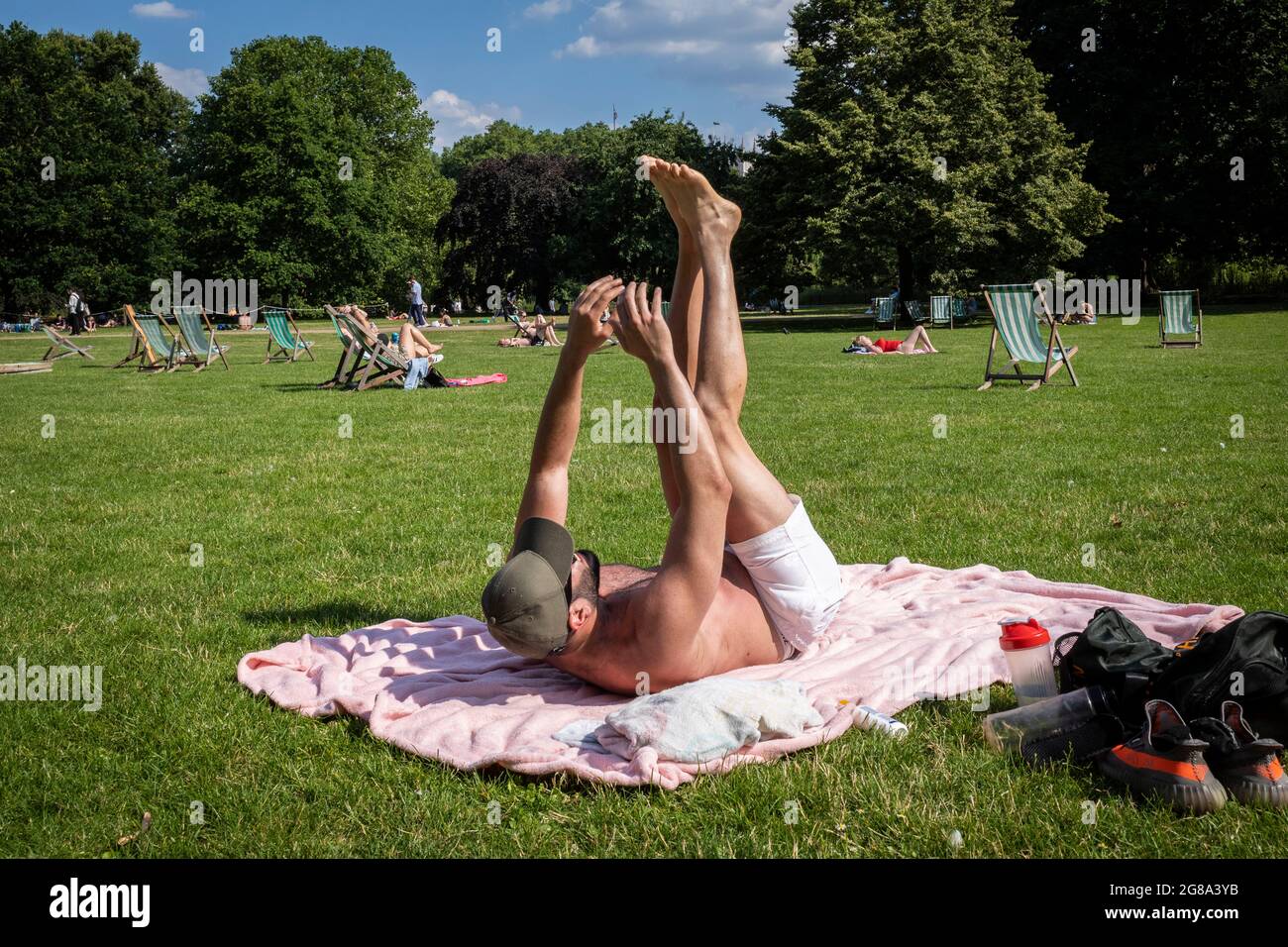 Londres, Reino Unido. 18 de julio de 2021. Clima en el Reino Unido - Un hombre haciendo ejercicio bajo el sol en St James's Park en el día más caluroso del año cuando las temperaturas superan los 31C. Crédito: Stephen Chung / Alamy Live News Foto de stock