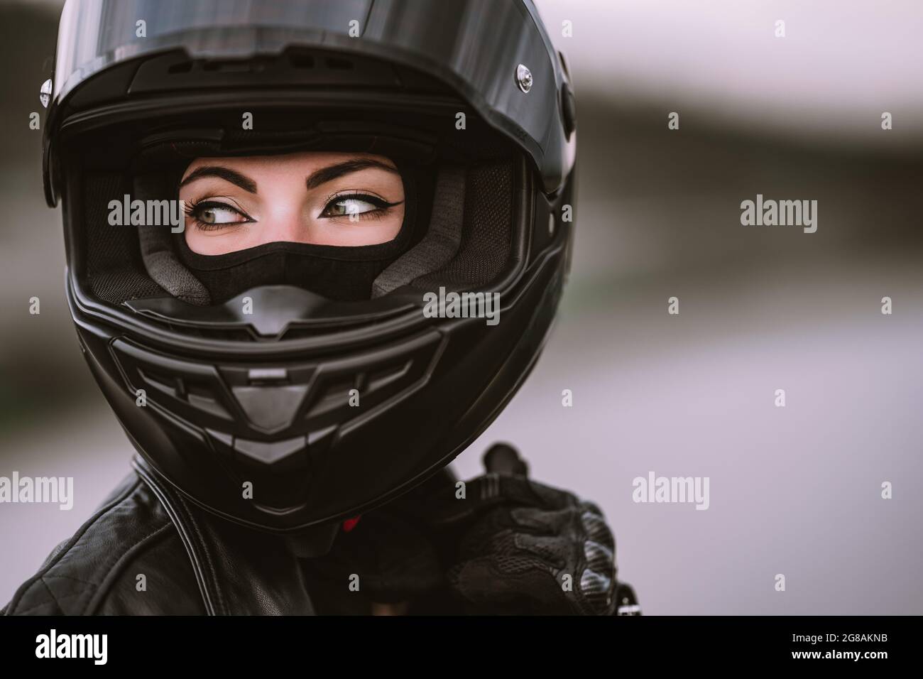 Retrato de una mujer motorista segura en el casco de la motocicleta.  Conductor joven biker mirando al aire libre. Cafés, estética de  motocicletas y vintage Fotografía de stock - Alamy