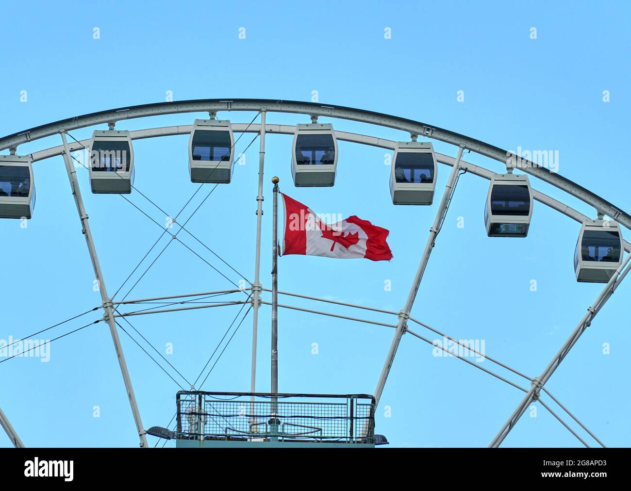 Canadá, Montreal - 11 de julio de 2021: Vista panorámica de la rueda de ferris La Grande Roue de Montreal en el Puerto Viejo de Montreal sobre cielos azules y nubes. La antigua P Foto de stock
