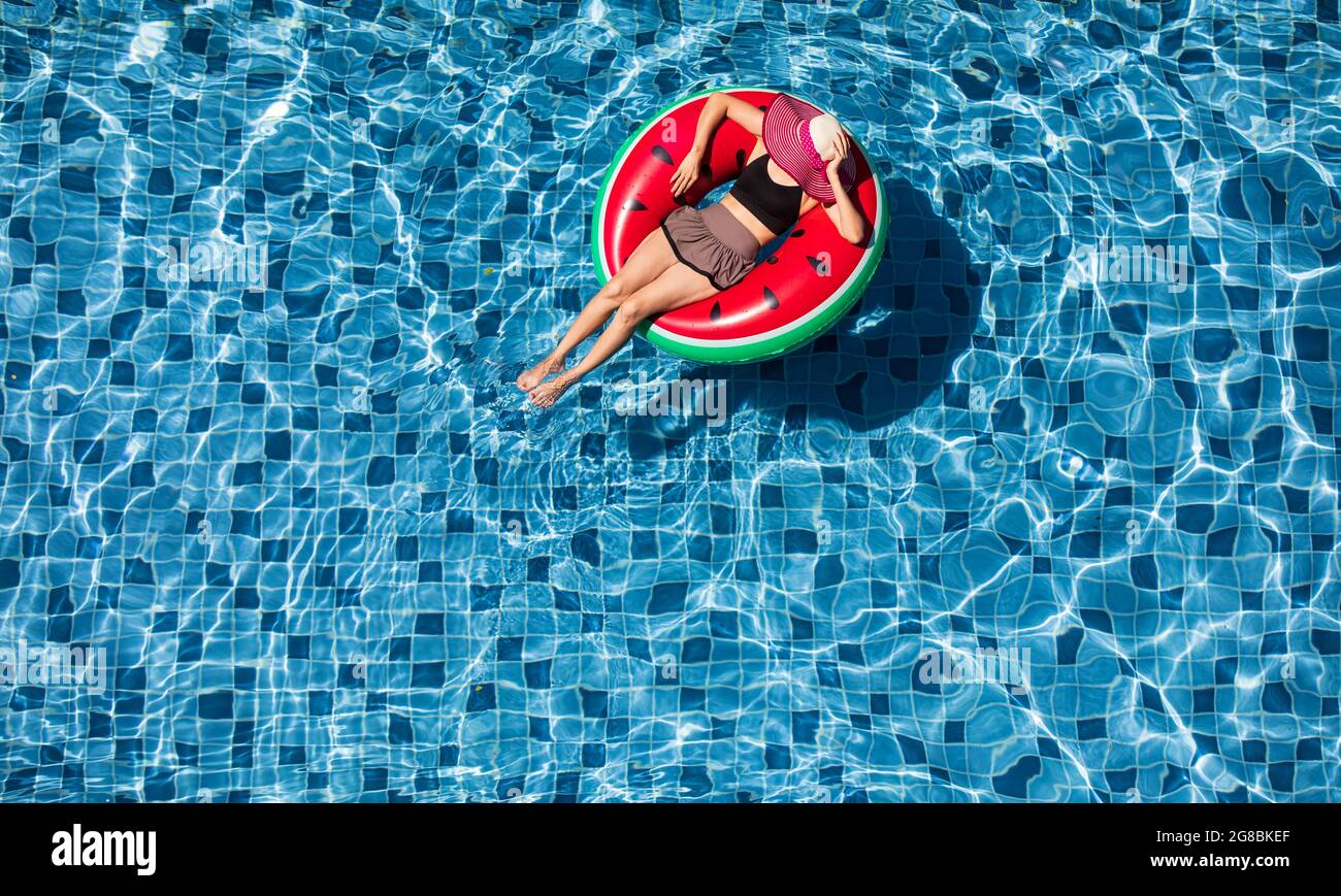 Top vista mujer de tiro vestir sombrero grande rojo tumbado en globo en  azul piscina de agua con espacio de copia, concepto para el lujo y estilo  de vida feliz Fotografía de