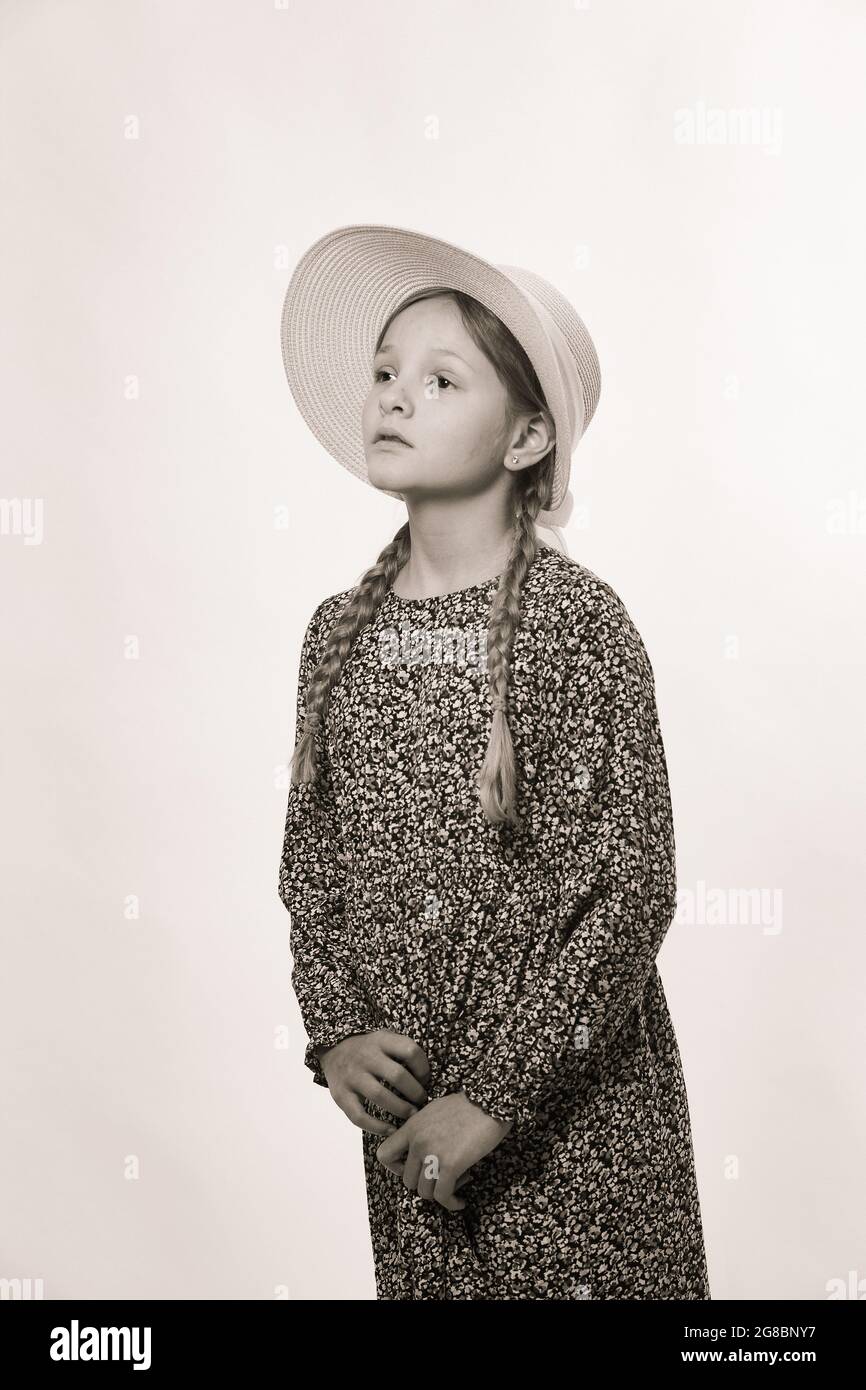Retrato de niña con sombrero , aislado sobre blanco. En b&w Foto de stock