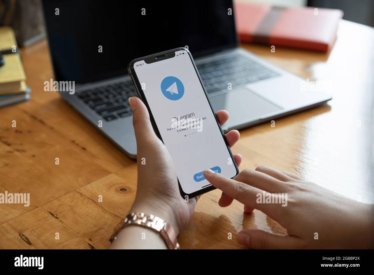CHIANG MAI, TAILANDIA, 23 DE ENERO de 2021 : Mujer mano sosteniendo iPhone 12 con el servicio de redes sociales Telegram en la pantalla. IPhone 12 fue creado y. Foto de stock