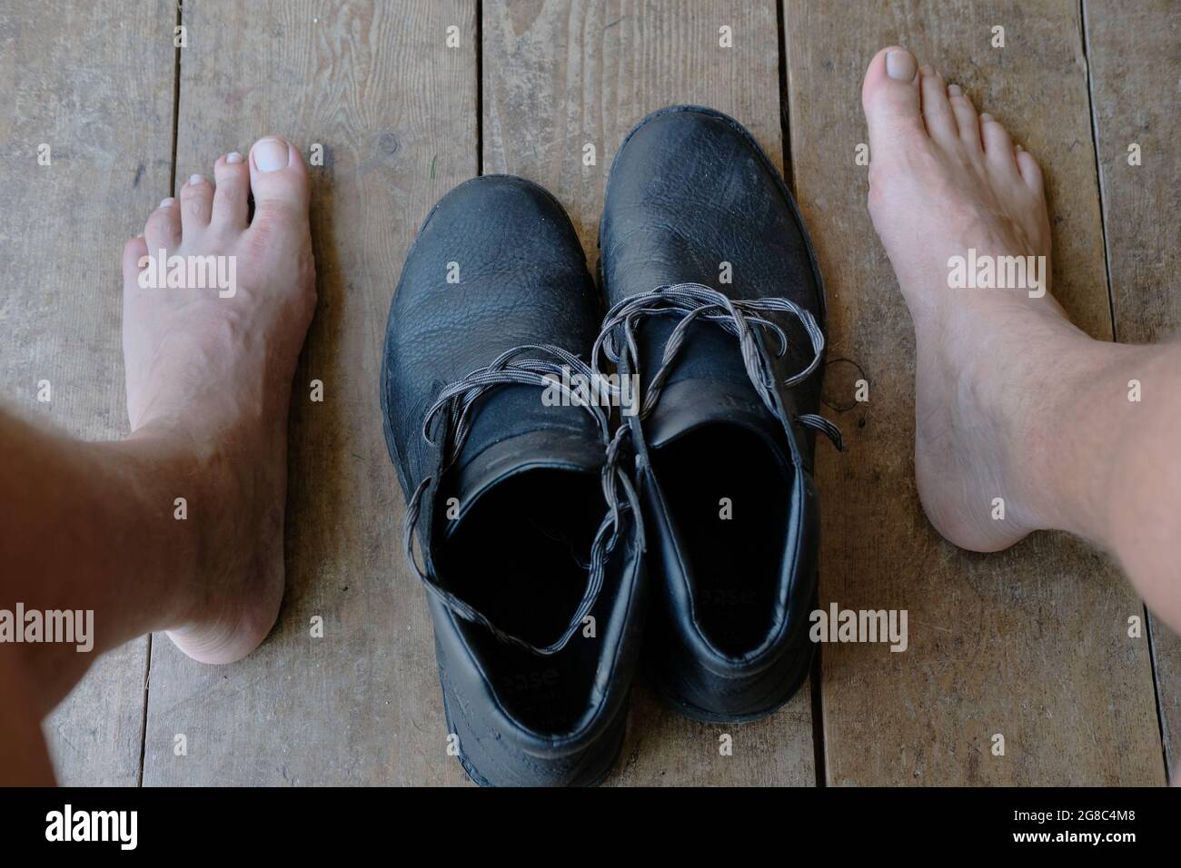 Un par de pies de hombre y sus zapatos. Foto de stock