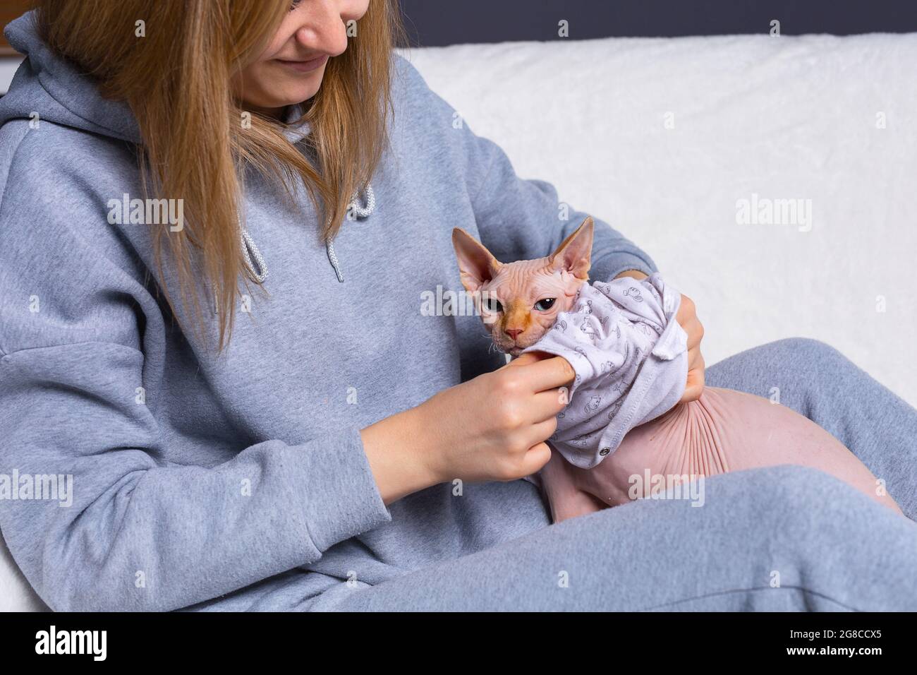 Mujer en ropa deportiva con su lindo gato sphynx para una caminata y ella se el gato Fotografía de stock Alamy