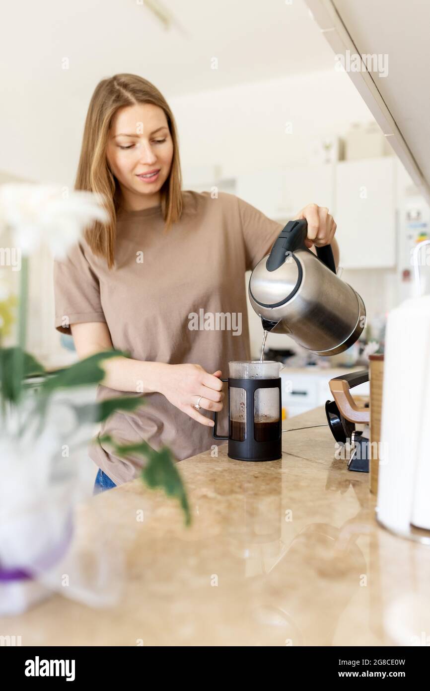 Mujer vertiendo agua para café por la mañana. Chica puso café en la prensa  francesa cafetera.Close Fotografía de stock - Alamy
