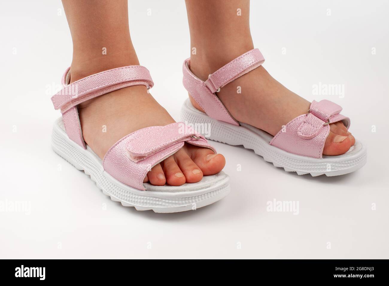 Sandalias para niños rosadas de cuero brillante con cierres de velcro,  suelas blancas planas aisladas sobre un fondo blanco. Un par de niños de  moda Fotografía de stock - Alamy