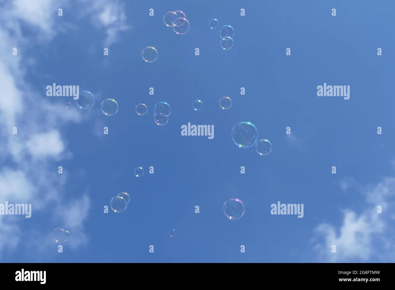 Burbujas de jabón flotando en el aire con un cielo azul con nubes en el  fondo Fotografía de stock - Alamy