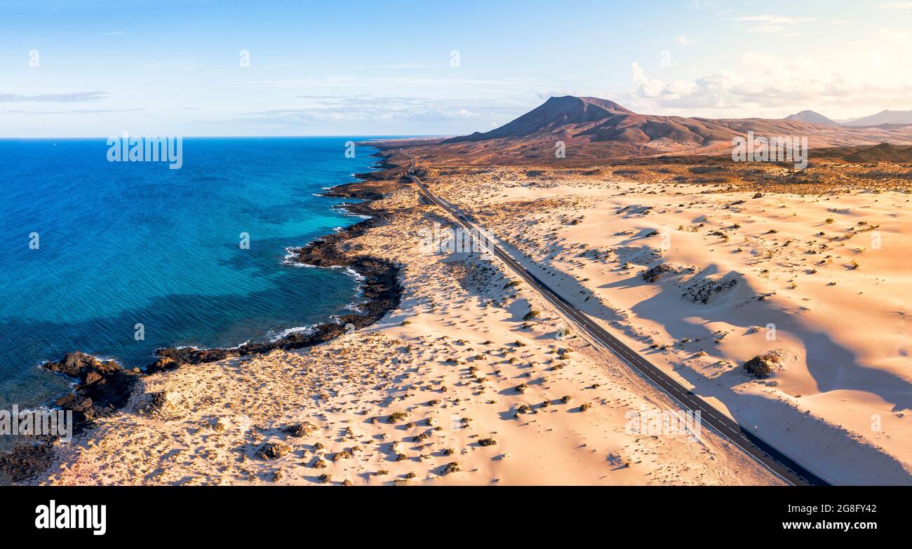 Camino vacío cruzando las dunas de arena con vistas al océano, Parque Natural de Corralejo, Fuerteventura, Islas Canarias, España, Atlántico, Europa Foto de stock