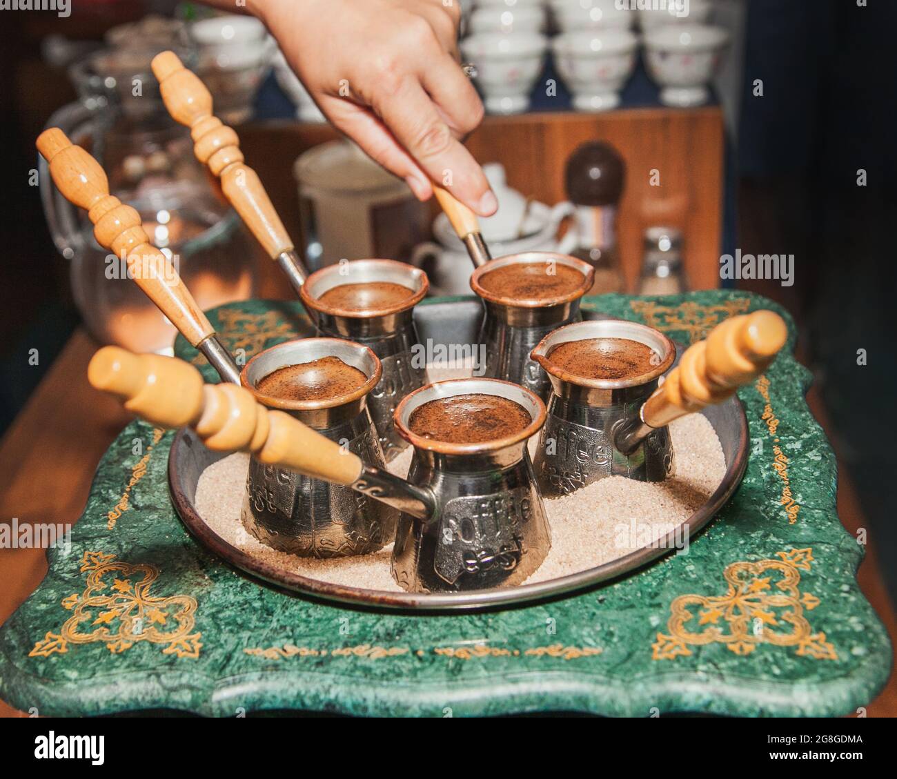 Mujer hace café turco en una cafetera con arena en el cezve. Café oriental  y oriental Fotografía de stock - Alamy