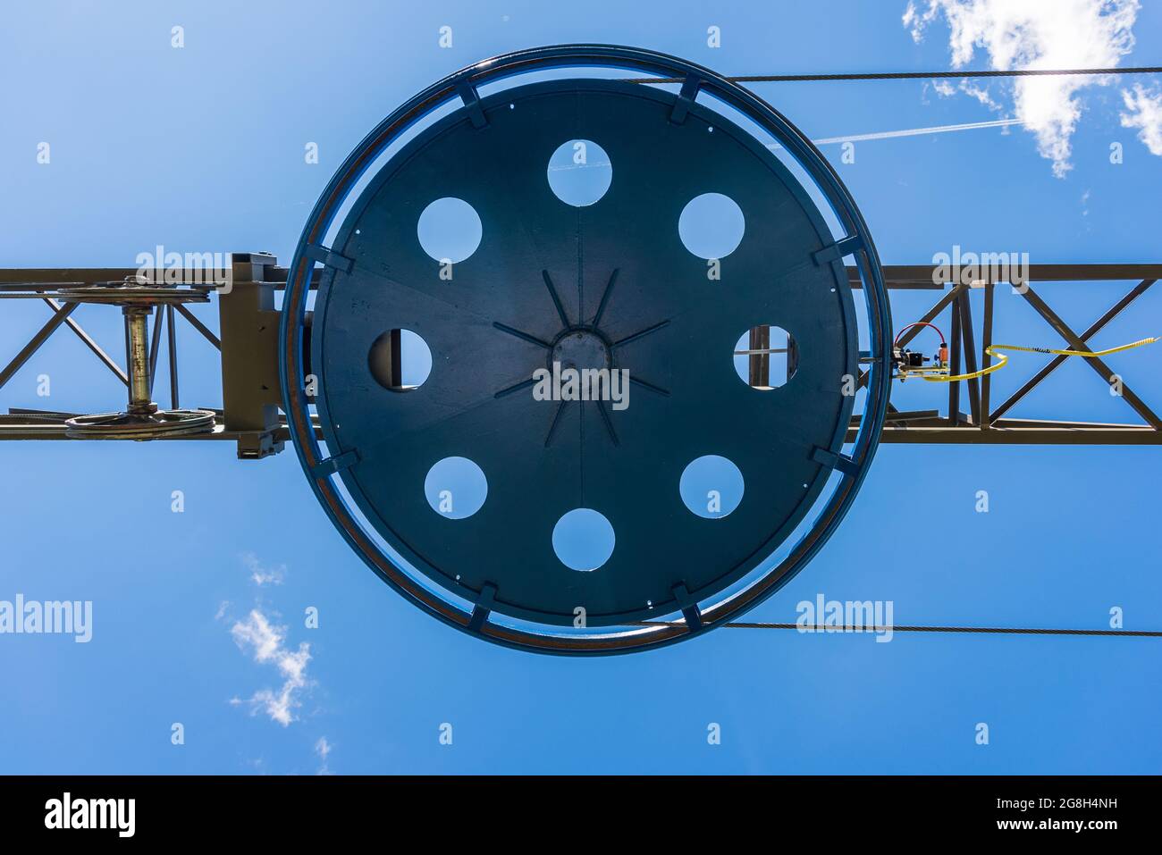 Fragmento del telesilla. Elementos de la estructura de acero, rueda, cuerdas de acero, tensiones, sensores, cables eléctricos en el fondo del cielo azul. Foto de stock