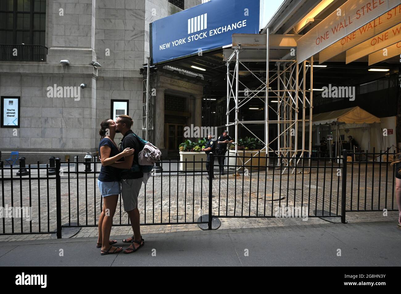 Dos personas se besan fuera de la Bolsa de Valores de Nueva York a lo largo  de Wall Street cuando los índices del mercado repuntaron después de una  brusca caída en el