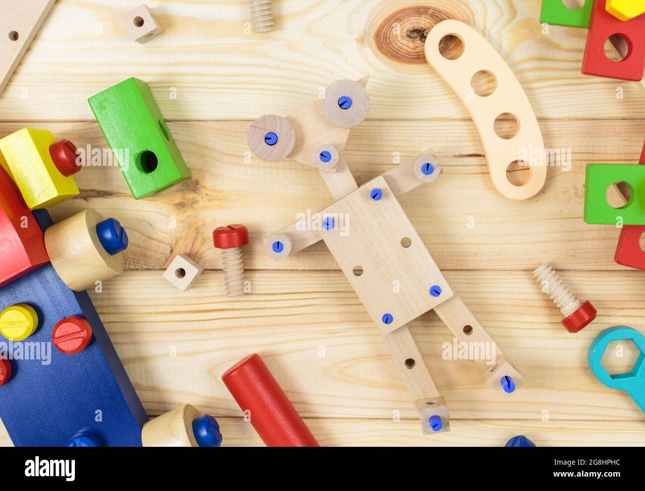 Un colorido kit de construcción de madera, un robot para niños en madera.  Juego de herramientas sobre mesa de madera. Juegos y herramientas para niños  en preescolar o guardería. Natural Fotografía de
