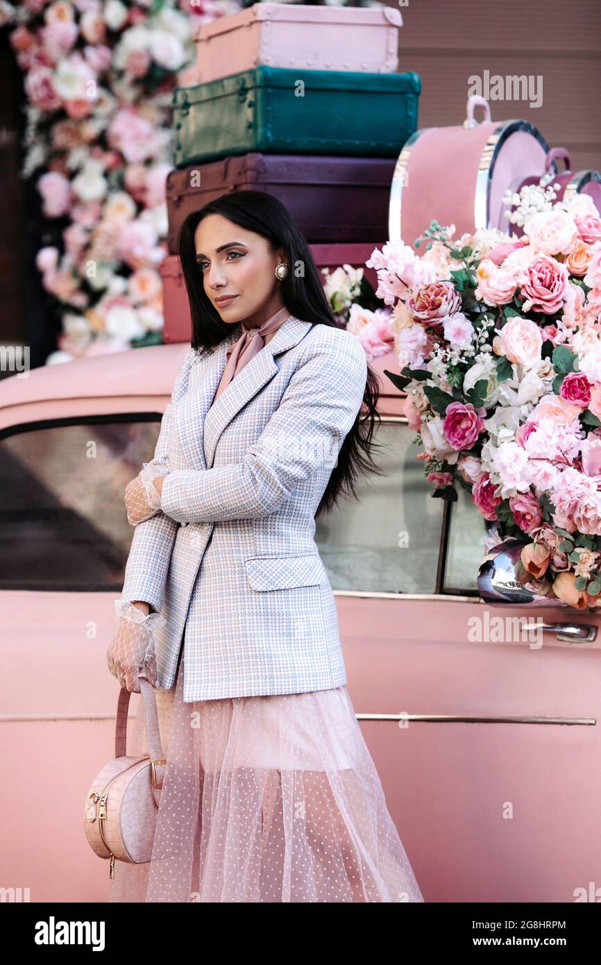 fábrica Machu Picchu Aspirar Modelo de dama de moda en falda chaqueta rosa, maquillaje y pelo negro  sobre coche retro decorado con rosas Fotografía de stock - Alamy