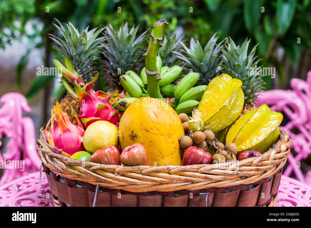 Una gran variedad de frutas exóticas en una cesta sobre fondo verde  Fotografía de stock - Alamy