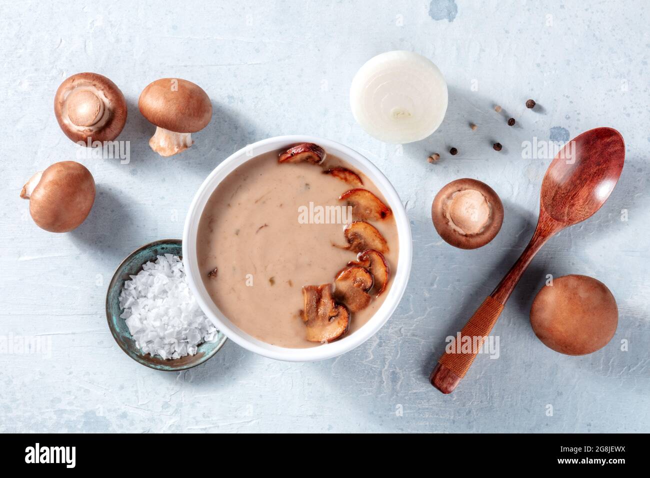 Ingredientes de sopa de setas. Champiñones, cebolla, sal, pimienta, y una cuchara de madera, encima de plano tiro. Comida orgánica simple Foto de stock