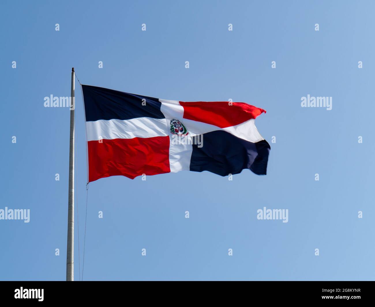 Las banderas dominicanas ondean con cielo azul en el fondo Foto de stock
